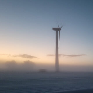 Windenergieanlage an Land im Nebel bei Sonnenuntergang