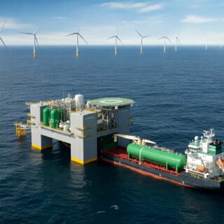 Offshore-Wasserstoffproduktionsplattform mit Windturbinen, die grünen Wasserstoff erzeugt. Ein Transportschiff wird beladen.