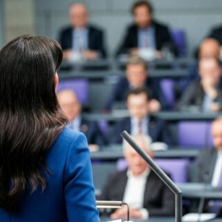 Eine Rednerin steht am Pult im Deutschen Bundestag und hält eine Rede vor den versammelten Abgeordneten.