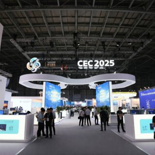 Blick auf den großen, leuchtenden Schriftzug 'CEC 2025' in einer Messehalle voller Besucher.