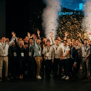 Eine Gruppe von Menschen feiert den erfolgreichen Start eines Startups mit Konfettiregen.