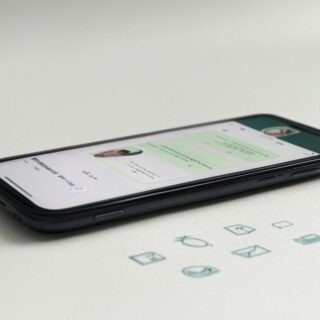 Smartphone mit WhatsApp-Chat, der neue Funktionen wie Themenkanäle, 3D-Avatare und Nachrichten mit Ablaufdatum zeigt, umgeben von Symbolen für Datenschutz und KI.