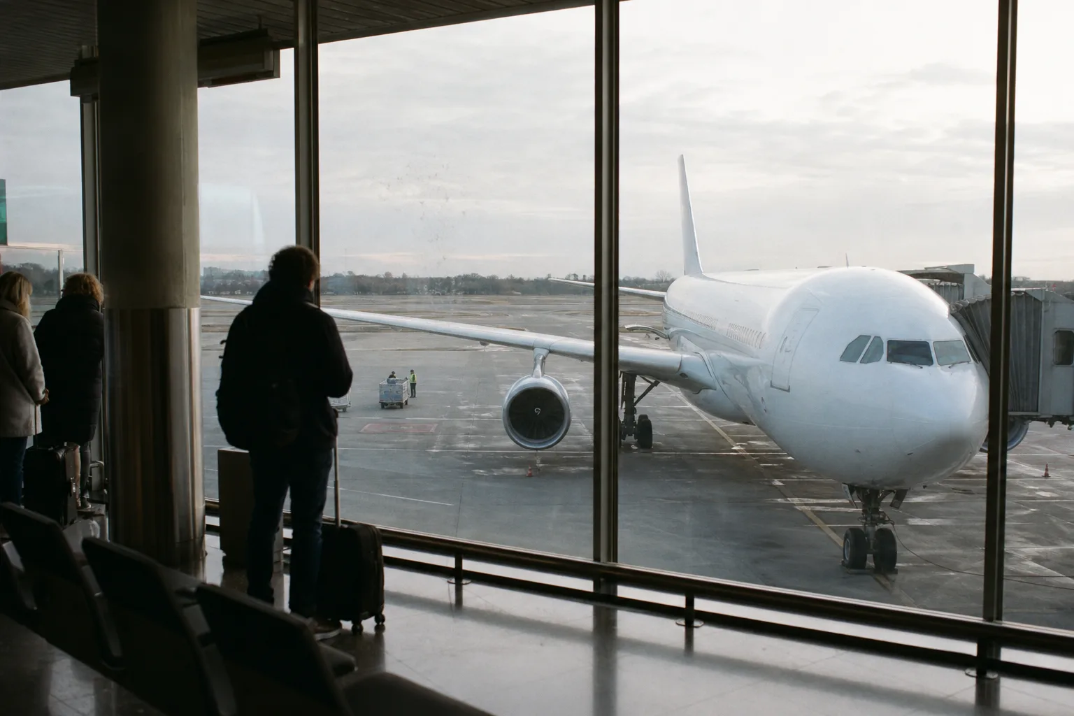 Unmarkiertes Langstreckenflugzeug an einem europäischen Abflugterminal bei bewölktem Morgenlicht.