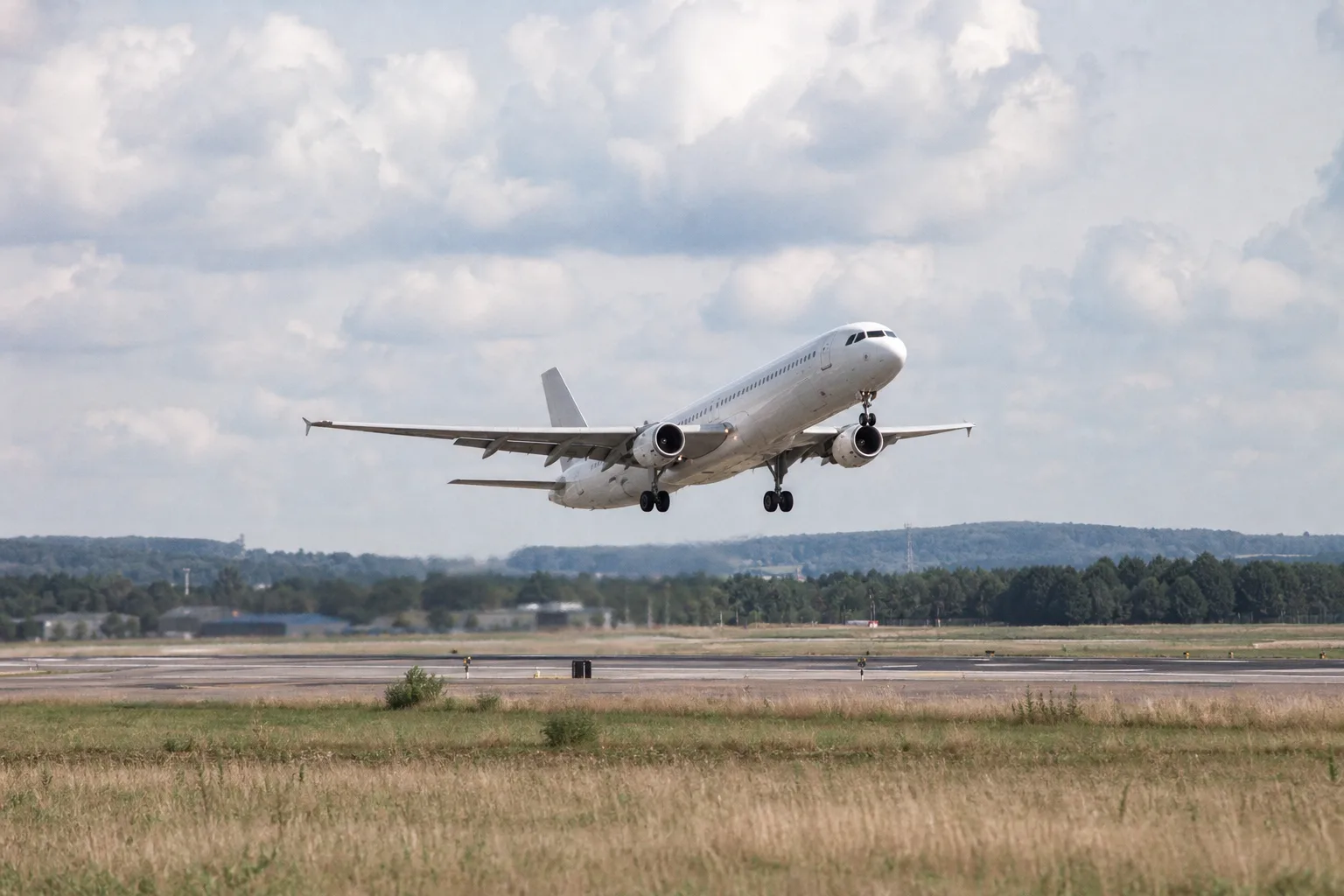 Unmarkiertes Passagierflugzeug hebt von einer Startbahn eines europäischen Flughafens ab.