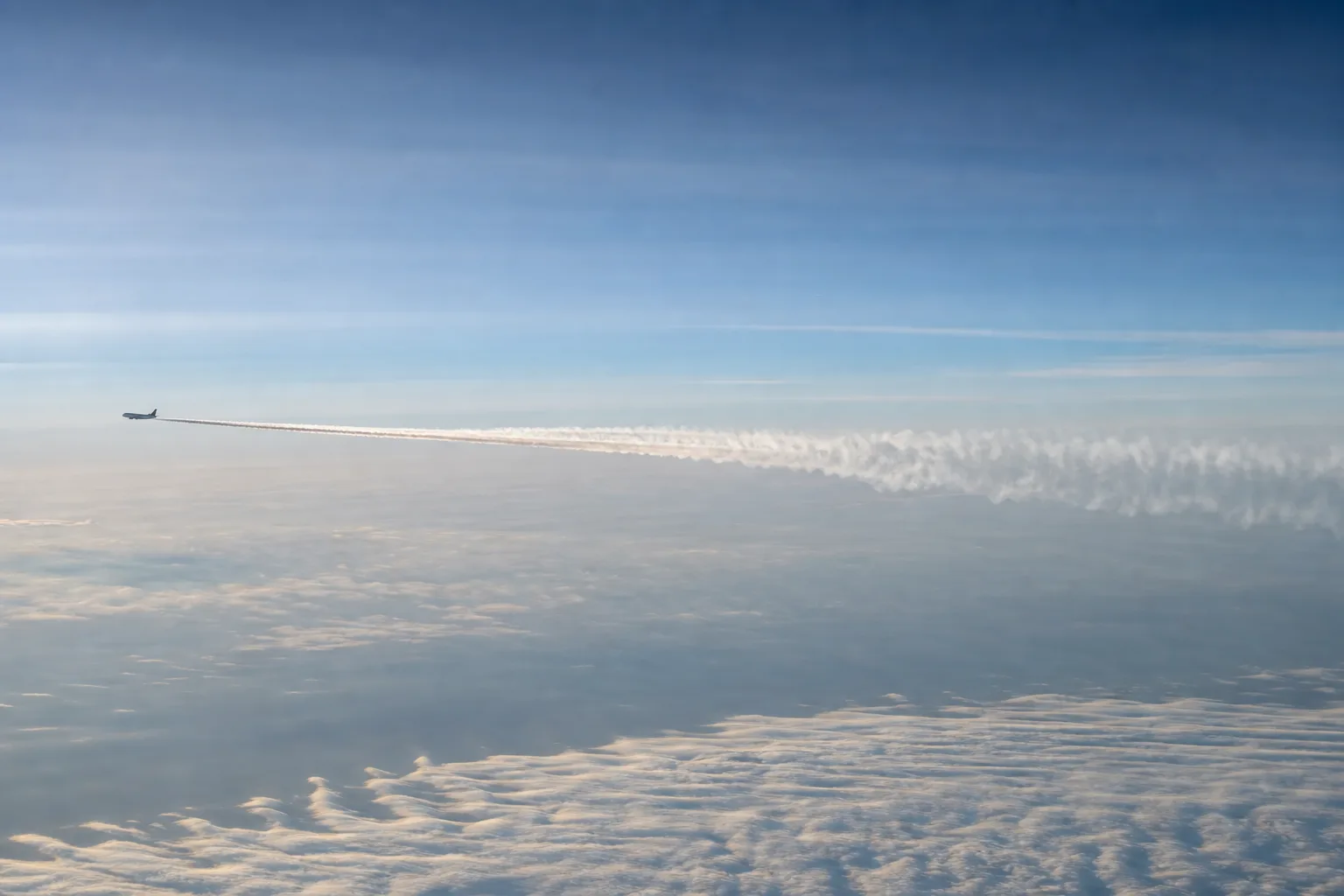Passagierflugzeug mit Kondensstreifen über dem Nordatlantik