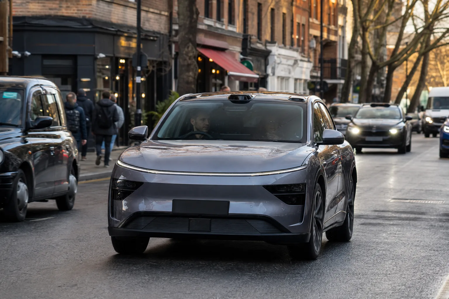 Unbeschriftetes Elektrofahrzeug auf einer Londoner Stadtstraße mit sichtbarem Fahrer auf dem vorderen Sitz